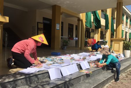 Kinder trocknen Hefte in der Sonne