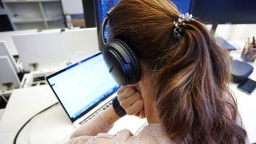 Frau mit Kopfhörer am Laptop