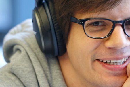 Man mit Kopfhörern schaut in Kamera