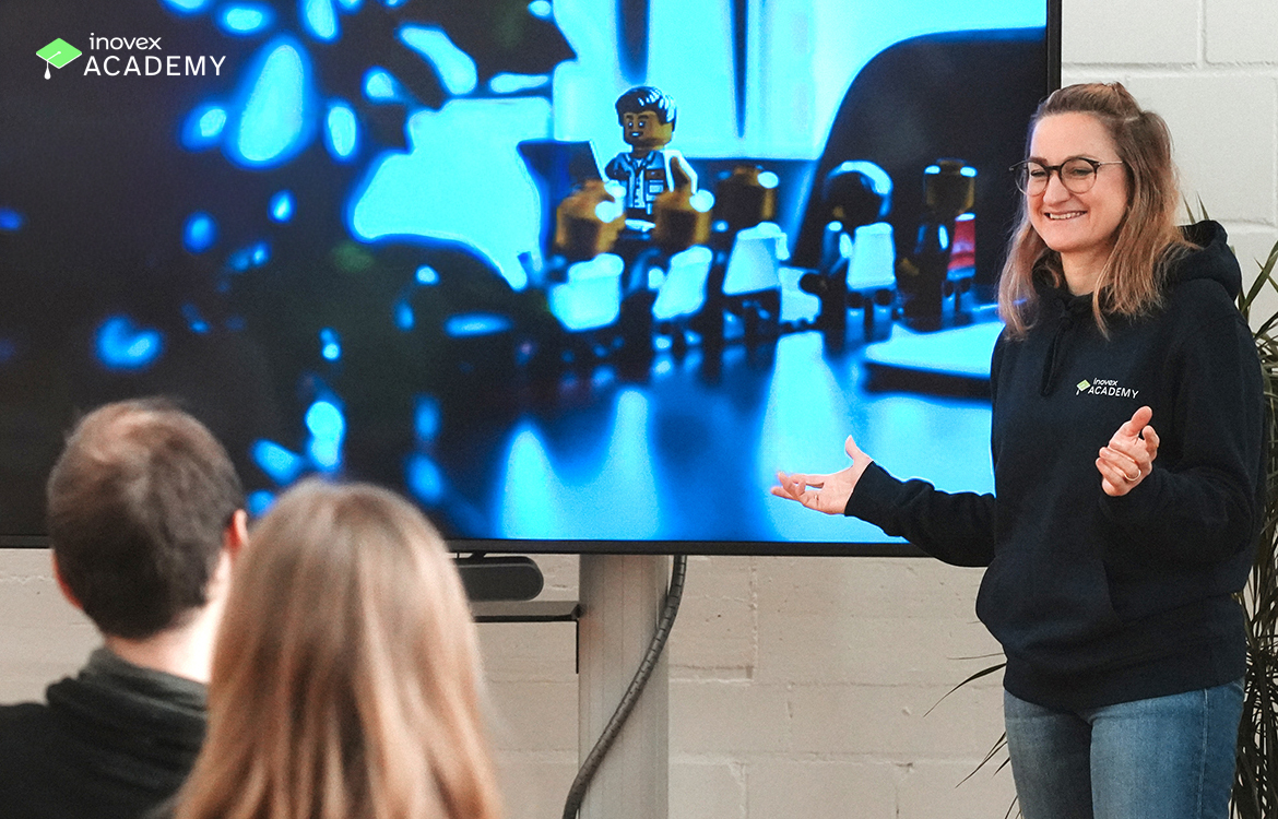 Eine Person steht neben einem Bildschirm und hält eine Präsentation