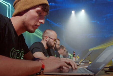 Männer sitzen vor Laptops