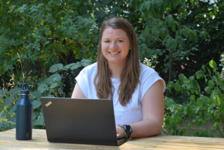 Frau vor Laptop in der Natur