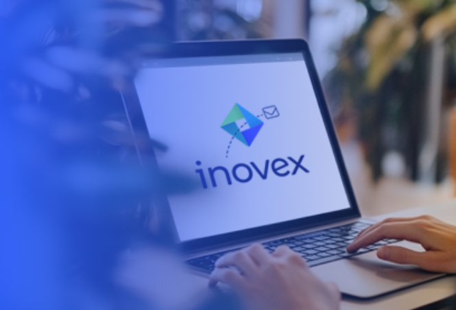 Ein Laptop auf dem das inovex Logo zu sehen ist. Hände einer Person tippen an diesem.