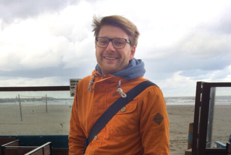 Mann in Jacke am Strand