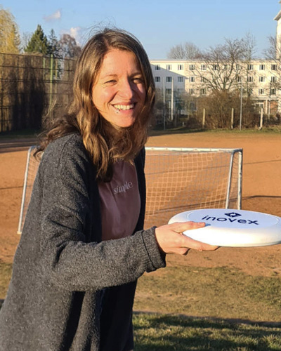 Lächelnde Julia Wayrauther mit inovex-Frisbee in der Hand